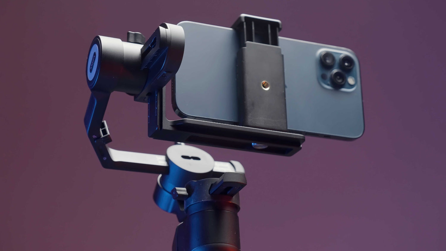Close-up of an iPhone mounted on a high-quality gimbal stabilizer against a purple background, showcasing the best gimbal for iPhone users seeking smooth and professional video recording.
